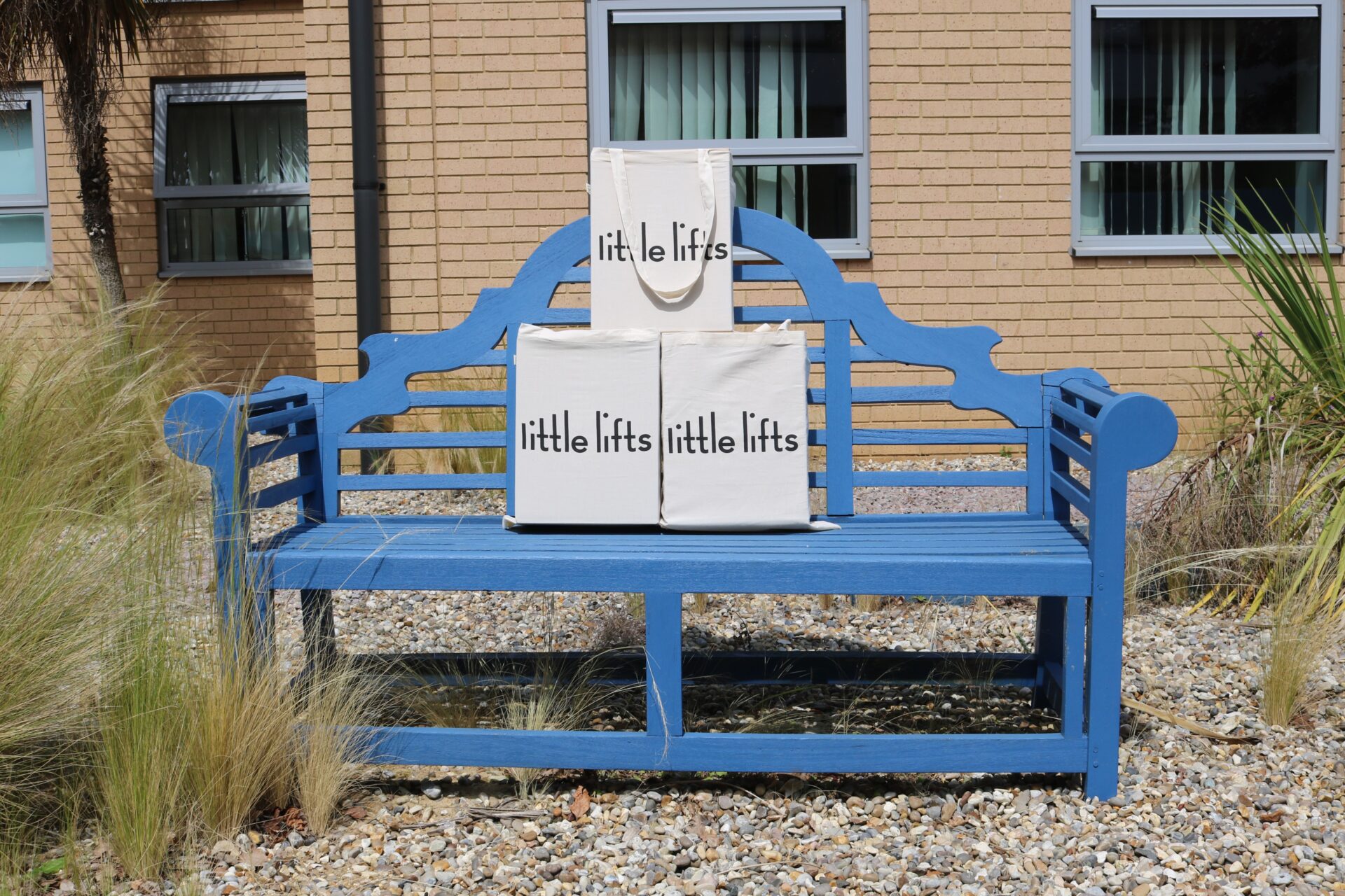 A picture of Little Lifts boxes sitting on a blue bench