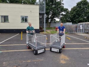 A picture of two members of the QEH with two big trollies